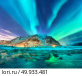 Aurora. Northern lights in Lofoten islands, Norway. Starry sky with polar lights. Night winter landscape with aurora, sea with sky reflection, stones, sandy beach and mountains. Green aurora borealis. Aurora. Nothern lights in Lofoten islands, Norway. Стоковое фото, агентство Ingram Publishing / Фотобанк Лори