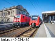 High speed train and old train on the railway station at sunset. Nuremberg, Germany. Modern intercity train on the railway platform. Industrial. Commuter trains on railroad. Passenger transportation. High speed train and old train on the railway station. Стоковое фото, агентство Ingram Publishing / Фотобанк Лори
