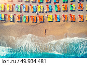 Aerial view of lying woman on the beach with colorful chaise-lounges. Young woman on the sea at sunset in Oludeniz, Turkey. Top view. Seascape with girl on the seashore, azure water and waves. Holiday. Aerial view of lying woman on the beach with colorful chaise-lounges. Стоковое фото, агентство Ingram Publishing / Фотобанк Лори