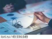 Businessman receive money in the envelope offered in file - anti bribery and corruption concepts. Стоковое фото, агентство Ingram Publishing / Фотобанк Лори