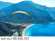 Paragliding in the sky. Paraglider tandem flying over the sea with blue water and mountains in bright sunny day. Aerial view of paraglider and Blue Lagoon in Oludeniz, Turkey. Extreme sport. Landscape. Paraglider tandem flying over the sea with blue water and mounta. Стоковое фото, агентство Ingram Publishing / Фотобанк Лори