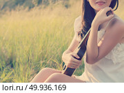 Beautiful Woman sitting  hand hugs violin in the meadow. Стоковое фото, агентство Ingram Publishing / Фотобанк Лори