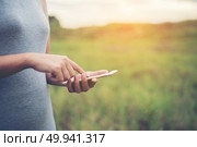 Young woman hands typing smartphone in the park. Стоковое фото, агентство Ingram Publishing / Фотобанк Лори