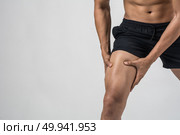 Young sport man with strong athletic legs holding knee with his hands in pain after suffering ligament injury  isolated on white.. Young sport man with strong athletic legs holding knee with his . Стоковое фото, агентство Ingram Publishing / Фотобанк Лори