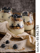 Yogurt parfait with blueberry and granola. Healthy breakfast concept served in mason jar with decorative spoons on wooden table. Стоковое фото, агентство Ingram Publishing / Фотобанк Лори
