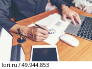 Close up hands signing terms of agreement documents of businessman on his desk, business signing concept. Стоковое фото, агентство Ingram Publishing / Фотобанк Лори