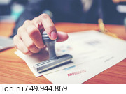 Close-up hand stamping of businessman for signing approval on documents , business concept. Стоковое фото, агентство Ingram Publishing / Фотобанк Лори