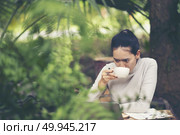 Concept of morning coffee and breakfast in an outdoor cafe. Hands of an unidentified young woman. Стоковое фото, агентство Ingram Publishing / Фотобанк Лори
