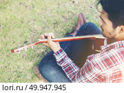Young hipster man practiced guitar in the park,happy and enjoy p. Young hipster man practiced guitar in the park,happy and enjoy playing guitar. Стоковое фото, агентство Ingram Publishing / Фотобанк Лори