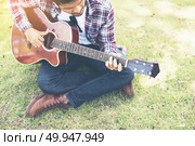 Young hipster man practiced guitar in the park,happy and enjoy p. Young hipster man practiced guitar in the park,happy and enjoy playing guitar. Стоковое фото, агентство Ingram Publishing / Фотобанк Лори