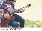 Portrait of young hipster man practiced guitar in the park,happy. Portrait of young hipster man practiced guitar in the park,happy and enjoy playing guitar. Стоковое фото, агентство Ingram Publishing / Фотобанк Лори