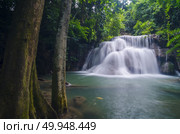 Erawan Waterfall, beautiful waterfall with sunlight rays in deep forest, Erawan National Park in Kanchanaburi, Thailand. Стоковое фото, агентство Ingram Publishing / Фотобанк Лори