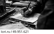 Close-up of a hand holding a pen, crafting a handwritten note on a paper strewn desk. Стоковое AI-изображение, AI-художник Данила Большаков / Фотобанк Лори