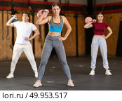 Girl in gym does exercises with kettlebell, lifts and lowers heavy kettlebell with one hand. Стоковое фото, фотограф Яков Филимонов / Фотобанк Лори