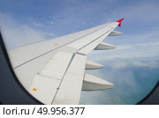 Airplane wing in the blue sky with white clouds. Стоковое фото, агентство Ingram Publishing / Фотобанк Лори