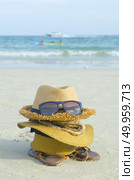 Summer beach bag with straw hat,towel,sunglasse s and flip flops on sandy beac. Стоковое фото, агентство Ingram Publishing / Фотобанк Лори