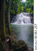 Erawan Waterfall, beautiful waterfall with sunlight rays in deep forest, Erawan National Park in Kanchanaburi, Thailand. Стоковое фото, агентство Ingram Publishing / Фотобанк Лори