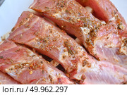 Uncooked seasoned pork ribs on a white cutting board. Isolated on white background. Стоковое фото, фотограф Светлана Акифьева / Фотобанк Лори