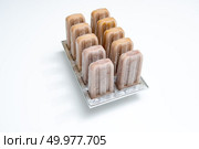 Ice cream lolly coffee in plastic molds on a white background with space for text. Summer dessert. Plastic molds with coffee homemade ice cream on white background with copy space. Cold dessert. Стоковое фото, агентство Ingram Publishing / Фотобанк Лори