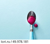 Natural smoothies of red berries in a spoon on a glass blue background and cocktail drop on the surface with soft shadows. Top view. Top view of smoothies of red berries in a spoon on a glass blue background. Стоковое фото, агентство Ingram Publishing / Фотобанк Лори