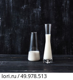 White milk in a glasses on a black background with place for text. Milk saving technology.. Two glasses with milk on a wooden dark table on a black. Natural organic dairy product. Стоковое фото, агентство Ingram Publishing / Фотобанк Лори