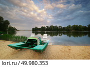 Catamaran on the river shore at sunset. . Стоковое фото, агентство Ingram Publishing / Фотобанк Лори