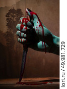 Closeup, Ghost woman or zombie hold knife for kill with blood violence in house of ruin, nightmare, horror of scary fear on hell is monster devil in halloween festival. Стоковое фото, агентство Ingram Publishing / Фотобанк Лори