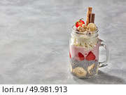 Yoghurt served with banana smoothie chia and strawberry in glass mason jar on a concrete background. Healthy breakfast. banana smoothie with chia seeds and strawberry yogurt in glass mason jar on a concrete background. Стоковое фото, агентство Ingram Publishing / Фотобанк Лори