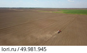 Agricultural works at farmlands. A tractor with a cultivator sowed a field. A farmer’s activity at the beginning of the spring season. Photo from the drone. Tractor cultivates the field, spring works on farmlands. Photo from the drone. Стоковое фото, агентство Ingram Publishing / Фотобанк Лори