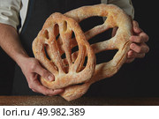 Close-up of a baker hands with fougas bread. Baker is holding fougas bread. Стоковое фото, агентство Ingram Publishing / Фотобанк Лори