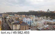 KIEV, UKRAINE - April 19, 2018: people and outdoor market on Kontraktova Square in Kiev city in spring. The former Greek Monastery and Ferris wheel on the Contract Square is central square in the historic Podil neighborhood of Kiev. Drone photo. KIEV, UKRAINE - April 19, 2018: people and outdoor market on Kontraktova Square in Kiev city in spring. Редакционное фото, агентство Ingram Publishing / Фотобанк Лори