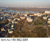 Aerial view from the drone, bird’s eye view to the Peizazhna alley, Vozdvizhenka, Podolsky bridge, St. Andrew’s Church, National Museum of Ukrainian History, Andreevsky descent.. A bird’s eye view, aerial view shooting from drone of the Podol district, oldest historical center of Kiev, the Dnieper River and the left bank of Dnieper in the city of Kiev, Ukraine. Стоковое фото, агентство Ingram Publishing / Фотобанк Лори