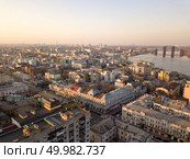 Aerial panoramic view from the drone to the oldest district of Kiev - Podol, Sahaidachnoho street, the Podolsky bridge, Havana bridge, old buildings and other historical places.. The panoramic bird’s eye view from drone to the central historical part of the city Kiev - the Podol district, the Dnieper River in Kiev, Ukraine at summer sunset. Стоковое фото, агентство Ingram Publishing / Фотобанк Лори