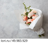 Beautiful pink roses of bouquet with white paper on a gray stone background. Beautiful pink roses. Стоковое фото, агентство Ingram Publishing / Фотобанк Лори