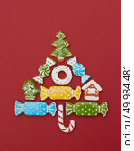 Beautiful Christmas tree made of gingerbread cookies with icing on a red background. Christmas card with cookies tree. Стоковое фото, агентство Ingram Publishing / Фотобанк Лори