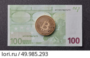 A symbolic coins of gold bitcoin on banknotes of one hundred euro exchange bitcoin cash for a euro on a dark background . Business, finance, technology concept of worldwide new cryptocurrency. Gold bitcoin on one hundred euro banknote on a dark background. Стоковое фото, агентство Ingram Publishing / Фотобанк Лори