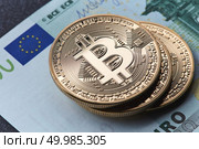 Stack of gold coins bitcoin stack on a euro bill. Digital coin money and digital payment system. Investing in crypto currency.. Stack of gold coins bitcoin stack on a euro bill. Стоковое фото, агентство Ingram Publishing / Фотобанк Лори