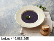 Dinner or lunch concept. Miso soup concept. Delicious vegan soup represented in white plate on table. Some sliced buns near it.. Vegan soup on table. Стоковое фото, агентство Ingram Publishing / Фотобанк Лори