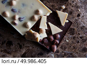 pieces of dark and white chocolate isolated on a dark marble background. pieces of dark and white chocolate. Стоковое фото, агентство Ingram Publishing / Фотобанк Лори