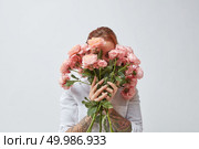 A happy woman with a tattoo on her hands hides her face behind a bouquet of fragrant pink roses. Mothers Day. Bouquet of beautiful roses in the hands of a girl. Стоковое фото, агентство Ingram Publishing / Фотобанк Лори