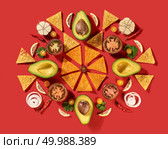 Round traditional mexican pattern with corn nachos chips, fresh natural fruits, vegetables, spices, chilli greens - ingredients for Guacamole dressing on a red background. Flat lay.. Mexican corn nachos chips, avocado, lemon, garlic, tomato, onion, parsley green as a round pattern - ingredients for tomato chili sauce on a red background. Top view. Стоковое фото, агентство Ingram Publishing / Фотобанк Лори