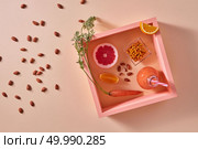 Homemade natural organic cocktail, made with grapefruits, orange, berries, carrots and nuts in glass jar. Healthy dietary food. Flat lay.. Organic vegetable smoothies with citrus fruits, almonds and sea-buckthorn in a bottle on a yellow paper background. Стоковое фото, агентство Ingram Publishing / Фотобанк Лори