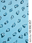 Neat rows of bits of ice for drinks isolated on a blue background with beautiful shadows, flat lay. rows of transparent pieces of glass ice on a blue background. Стоковое фото, агентство Ingram Publishing / Фотобанк Лори