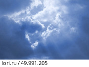 Rays of sunshine breaks through the dark blue clouds. Concept of hope for the best, mood changes, the breakthrough goal. Rays of sunshine breaks through the dark blue clouds. Стоковое фото, агентство Ingram Publishing / Фотобанк Лори