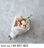 Wedding bouquet of peach roses with white paper on a gray stone background. Beautiful peach roses. Стоковое фото, агентство Ingram Publishing / Фотобанк Лори