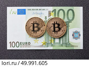 Gold coins bitcoin and one hundred euro banknote on a dark background. Exchange bitcoin cash for a dollar.. Gold coins bitcoin and one hundred euro banknote on a dark background. Стоковое фото, агентство Ingram Publishing / Фотобанк Лори