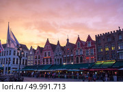 buildings in the Market Square on sunset in Bruges, natural light. They are not really medieval but mostly modern reconstructions of the medieval styles.. buildings in the Market Square. Редакционное фото, агентство Ingram Publishing / Фотобанк Лори