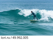 Surfer in action on the ocean waves on a cloudy day. Стоковое фото, агентство Ingram Publishing / Фотобанк Лори