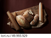 Fresh crunchy bread basket on the black table. Assortment of different types of bread. Стоковое фото, агентство Ingram Publishing / Фотобанк Лори