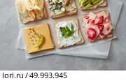 Different kinds of colorful sandwiches on white chalkboard background from above (top view). Party starter or appetizer - flat lay composition.. Different kinds of sandwiches. Стоковое фото, агентство Ingram Publishing / Фотобанк Лори